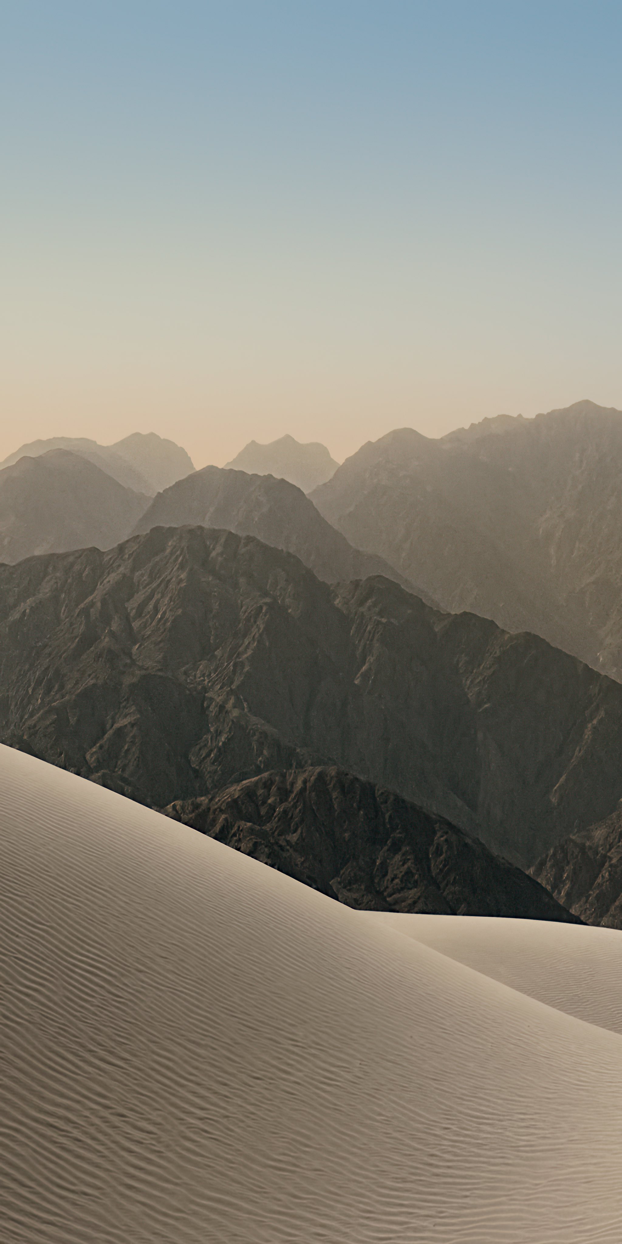 Gentle Sand Dunes Leading to Mountainous Terrain